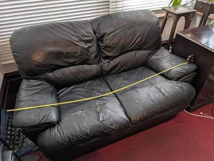 Photo of free Black leather sofa, two persons. (Some damage) (Leytonstone E11) #1