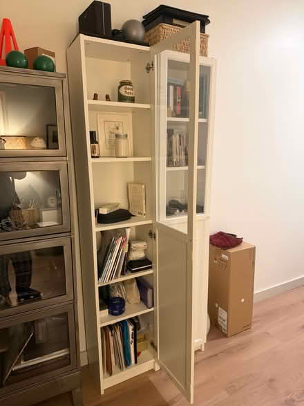 Photo of free Tall shelving unit with glass door (New Rochelle) #1