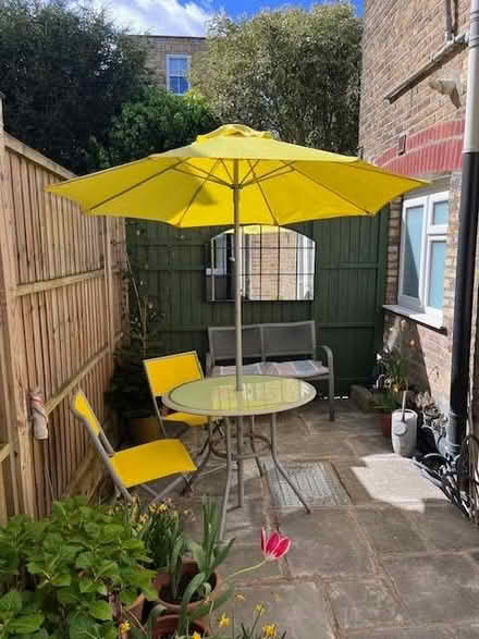 Photo of free Grey round garden table, 4 chairs & parasol (yellow) (Putney SW15) #1