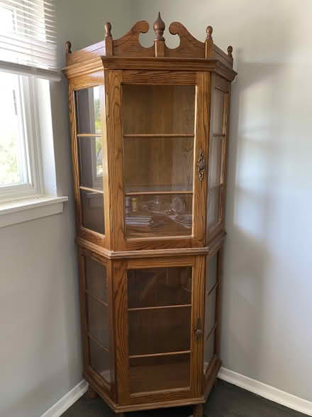 Photo of free Oak Corner Cabinet w/ Glass Shelves (Near Parkville High School) #1