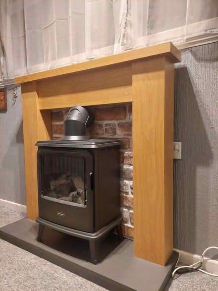 Photo of free Wood fire surround with slate effect base and downlighters. (Howey LD1) #1
