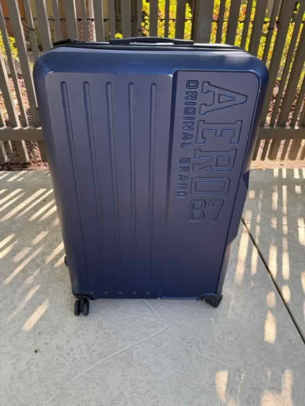 Photo of free Large plastic suitcase on casters (1075 Valencia Avenue) #1